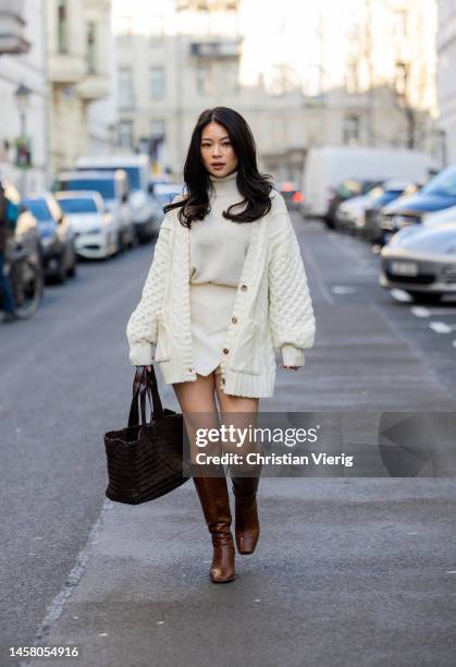 TingTing Lai wears creme white cardigan, shorts, turtleneck, brown bag, knee high boots during the Berlin Fashion Week AW23 on January 19, 2023 in...