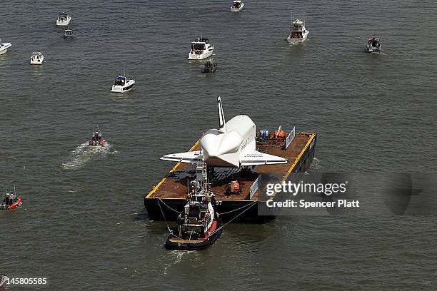 Flotilla surrounds NASA space shuttle Enterprise as it is carried by barge up the Hudson River on route to its permanent home at the Intrepid Sea,...