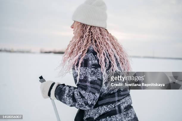 middle aged woman skiing in snowy winter - スキーパンツ ストックフォトと画像