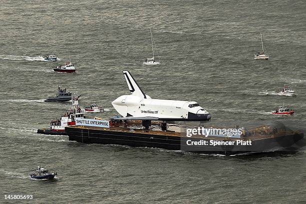 Flotilla surrounds NASA space shuttle Enterprise as it is carried by barge up the Hudson River on route to its permanent home at the Intrepid Sea,...