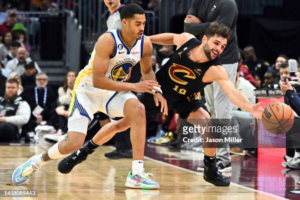Jordan Poole of the Golden State Warriors and Raul Neto of the Cleveland Cavaliers battle for a loose ball during the second half at Rocket Mortgage...