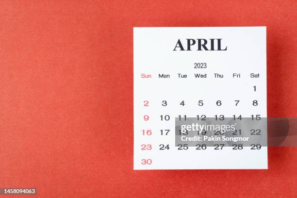 calendar desk 2023: april is the month for the organizer to plan and deadline with a red paper background. - avril photos et images de collection