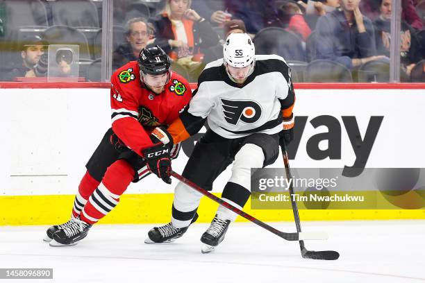 Taylor Raddysh of the Chicago Blackhawks and Rasmus Ristolainen of the Philadelphia Flyers challenge for the puck at Wells Fargo Center on January...