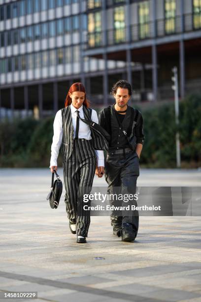 Alice Barbier wears a white shirt, a black tie, a black and gray striped print pattern sleeveless blazer jacket, matching black and gray striped...