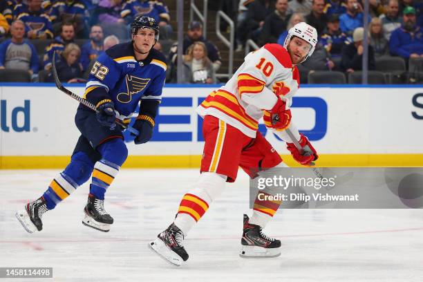 Jonathan Huberdeau of the Calgary Flames skates against Noel Acciari the St. Louis Blues at Enterprise Center on January 12, 2023 in St Louis,...