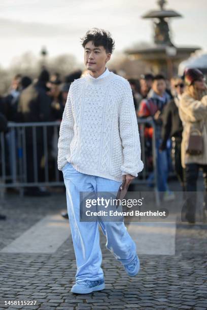 Guest wears a white t-shirt, a white latte braided wool with embroidered white pearls oversized pullover, pale blue velvet ribbed large pants, a...