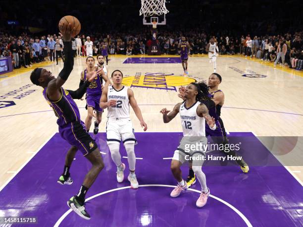 Dennis Schroder of the Los Angeles Lakers scores to take a 122-120 lead in front of Ja Morant and Desmond Bane of the Memphis Grizzlies during the...
