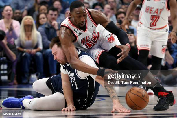 Luka Doncic of the Dallas Mavericks scrambles for the ball against Bam Adebayo of the Miami Heat in the second quarter at American Airlines Center on...
