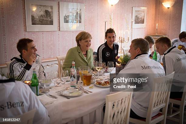In this photo provided by the German Government Press Office , German Chancellor Angela Merkel talks to German National Team players Philipp Lahm ,...
