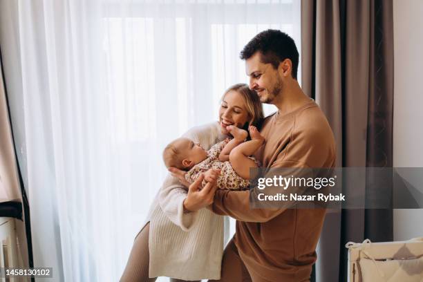 the young cheerful parents are happy for the baby - baby with parents imagens e fotografias de stock