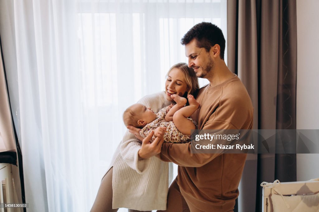 The young cheerful parents are happy for the baby