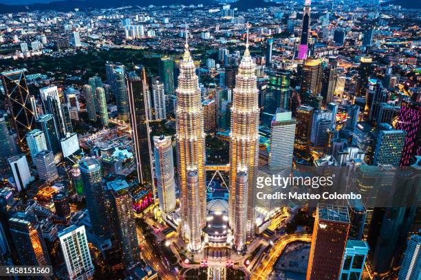 aerial view of petronas twin towers at night - kuala lumpur twin tower stock pictures, royalty-free photos & images