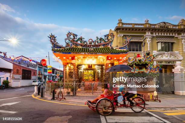 woman on rickshaw in the old town, george town, malaysia - georgetown world heritage building stockfoto's en -beelden