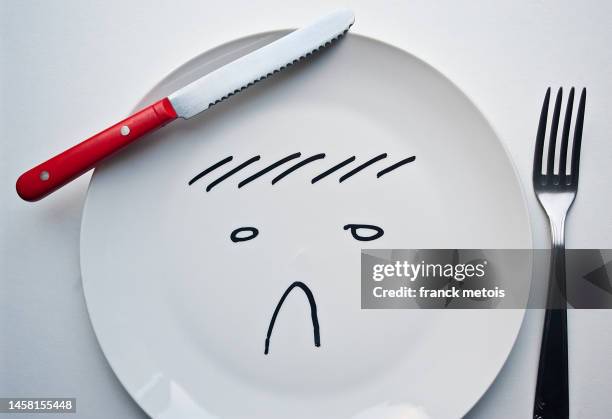 sad face drawn on a plate - sad face drawing - fotografias e filmes do acervo