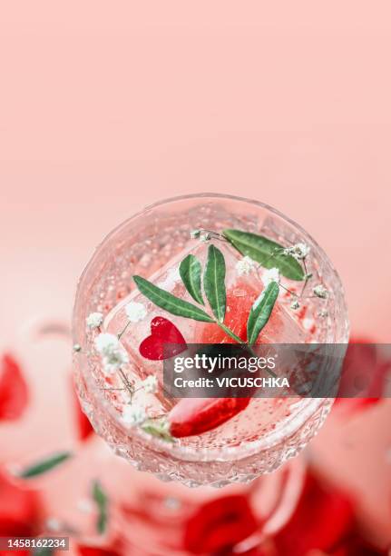 close up of cocktail with ice cube  and red heart - pink champagne stock pictures, royalty-free photos & images