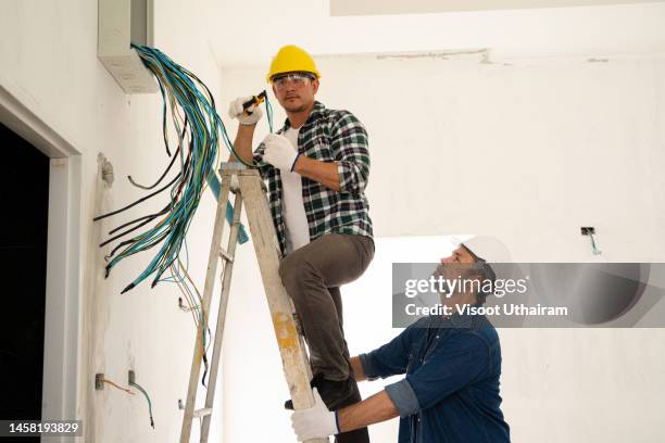 electrician installing electrical wiring,installing wiring in a new house project. - revestimento equipamento de construção - fotografias e filmes do acervo