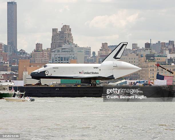 The Space Shuttle Enterprise as seen from the New Jersey side of the Hudson River is transported to the Intrepid Sea, Air & Space Museum on June 6,...