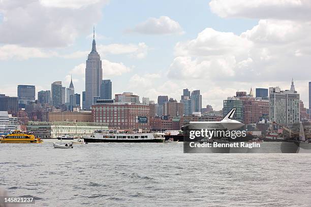 The Space Shuttle Enterprise as seen from the New Jersey side of the Hudson River is transported to the Intrepid Sea, Air & Space Museum on June 6,...