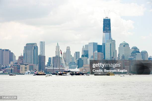 The Space Shuttle Enterprise as seen from the New Jersey side of the Hudson River is transported to the Intrepid Sea, Air & Space Museum on June 6,...