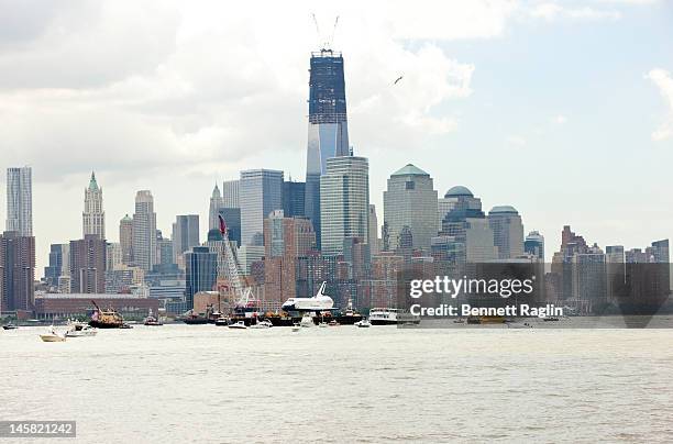 The Space Shuttle Enterprise as seen from the New Jersey side of the Hudson River is transported to the Intrepid Sea, Air & Space Museum on June 6,...