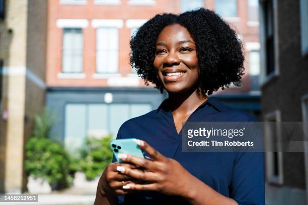 woman looking up using smart phone, big smile - testimonial portrait smile stock-fotos und bilder