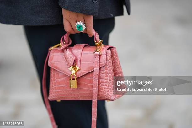 Guest wears a gray blazer jacket, black suit pants, a diamonds and large emerald ring, a pale pink shiny leather crocodile print pattern handbag from...