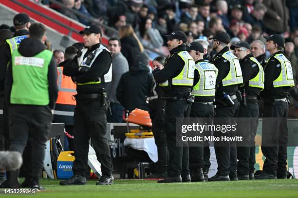 Police are seen on the pitch as the game is paused due to a drone flying above the pitch during the Premier League match between Southampton FC and...