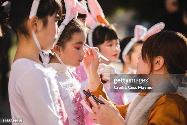 Woman makes up a group of girls dressed as rabbits during the Chinese New Year Parade on January 21, 2023 in Barcelona, Spain. The Chinese community...