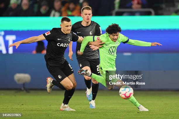 Kevin Paredes of VfL Wolfsburg runs with the ball whilst under pressure from Maximilian Eggestein of SC Freiburg during the Bundesliga match between...