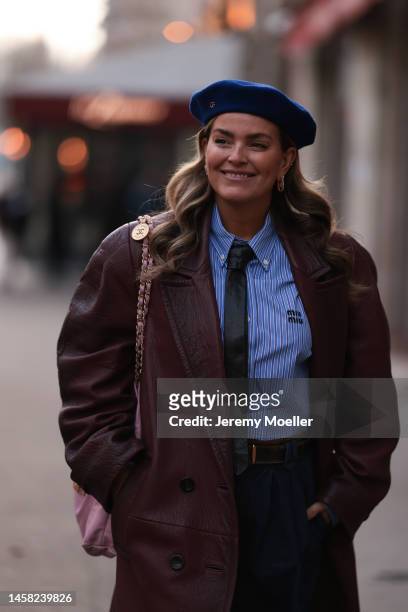Janka Polliani seen wearing a dark blue beret by Gucci, a cropped blue striped blouse by Miu Miu, a pink Chanel bag, a long bordeaux leather coat,...