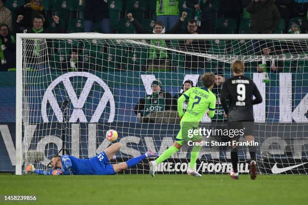 Luca Waldschmift of VfL Wolfsburg scores the team's sixth goal from a penalty as Mark Flekken of SC Freiburg reacts after not making a save during...