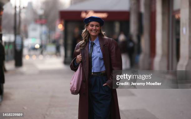 Janka Polliani seen wearing a dark blue beret by Gucci, a cropped blue striped blouse by Miu Miu, a pink Chanel bag, a long bordeaux leather coat,...