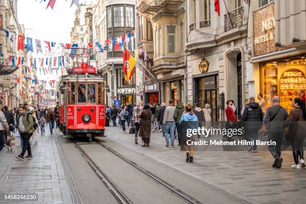 menschen, die zu fuß gehen und nostalgische straßenbahn auf der istiklal avenue in istanbul, türkei - straßenbahnstrecke stock-fotos und bilder