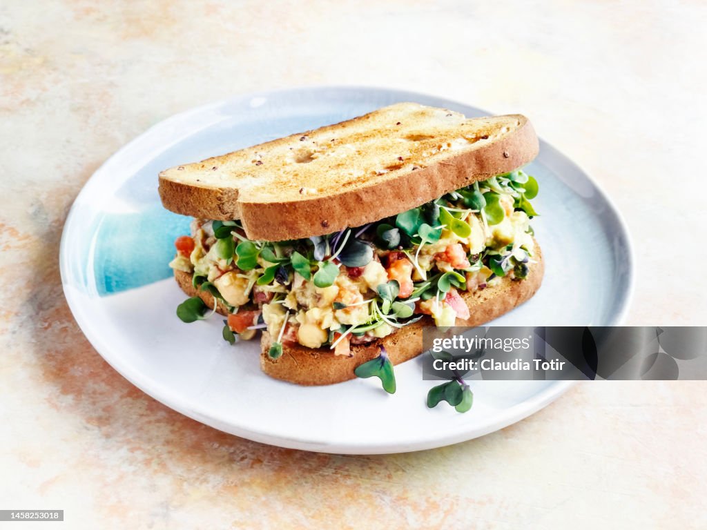 Vegetarian sandwich on a plate on yellow background