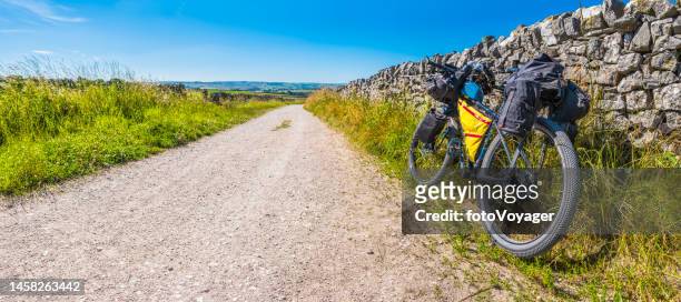 bikepacking bike on earth road in idyllic summer landscape panorama - derbyshire stock pictures, royalty-free photos & images