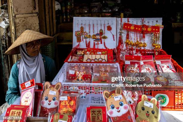 An Indonesian sells Chinese Lunar Year accessories ahead to the Lunar New Year celebrations on January 22, 2023 in Semarang, Java, Indonesia. The...