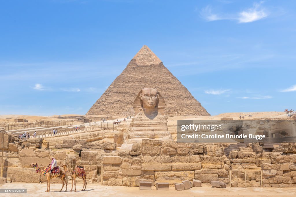 Man Sitting On A Camel At The Pyramids of Giza And The Sphinx, Giza Necropolis, Egypt