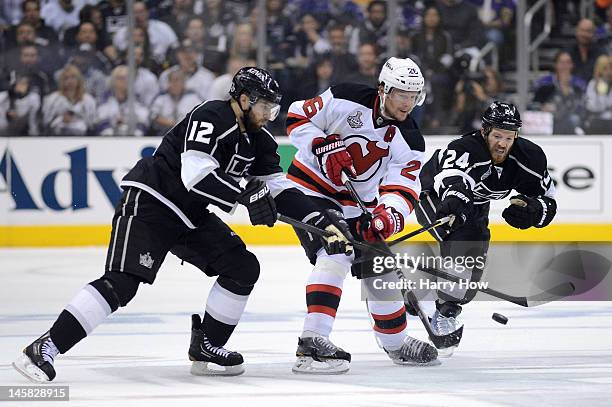 Patrik Elias of the New Jersey Devils skates against Simon Gagne and Colin Fraser of the Los Angeles Kings Game Four of the 2012 Stanley Cup Final at...