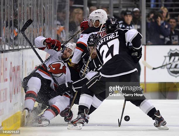 Travis Zajac of the New Jersey Devils is checked by Jeff Carter of the Los Angeles Kings in the first period alongside Alec Martinez of the Kings in...