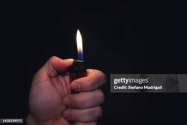 lighter with the flame held in the hand - flint stock pictures, royalty-free photos & images