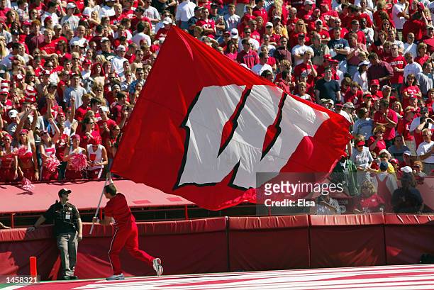 Wisconsin Badgers cheerleader runs with the school banner during the NCAA football game against the Arizona Wildcats on September 21, 2002 at Camp...