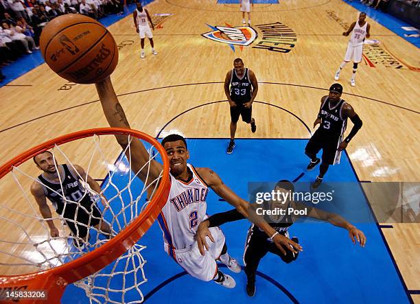 Thabo Sefolosha of the Oklahoma City Thunder dunks the ball against Daniel Green and Manu Ginobili of the San Antonio Spurs in Game Six of the...