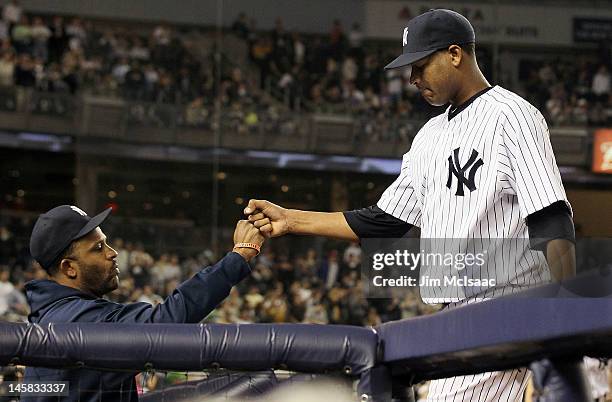 Sabathia of the New York Yankees greets teammate Ivan Nova as he comes out of the game against the Tampa Bay Rays in the ninth inning at Yankee...