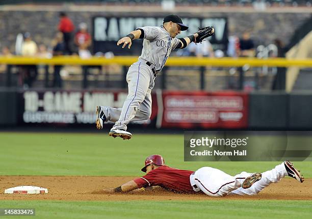Marco Scutaro of the Colorado Rockies jumps over the top of a sliding Gerardo Parra of the Arizona Diamondbacks at Chase Field on June 6, 2012 in...