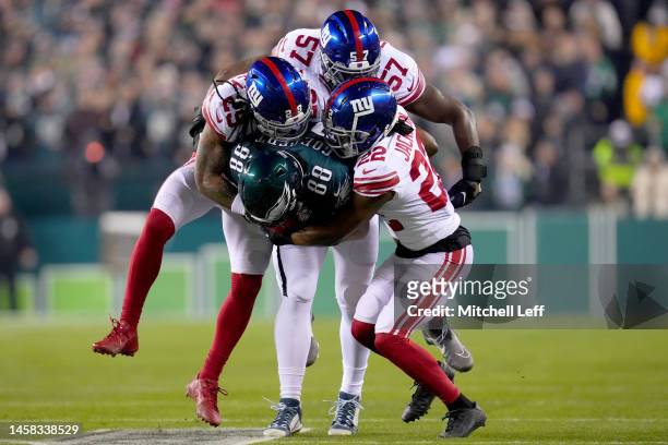Xavier McKinney, Jarrad Davis and Aaron Robinson of the New York Giants tackle Dallas Goedert of the Philadelphia Eagles during the first quarter in...