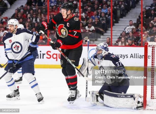 Brady Tkachuk of the Ottawa Senators attempts to screen Connor Hellebuyck of the Winnipeg Jets during the second period at Canadian Tire Centre on...