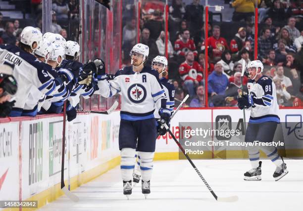Mark Scheifele of the Winnipeg Jets celebrates his second period goal against the Ottawa Senators with his teammates on the bench at Canadian Tire...
