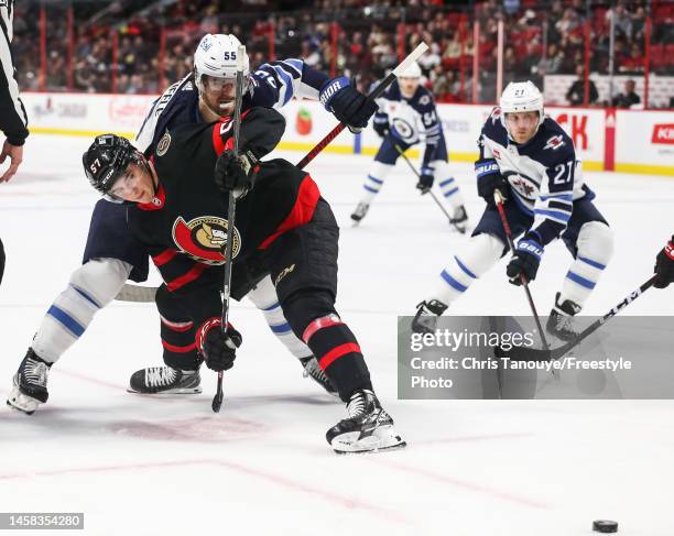 Mark Scheifele of the Winnipeg Jets battles for the puck with Shane Pinto of the Ottawa Senators after a third period face-off at Canadian Tire...