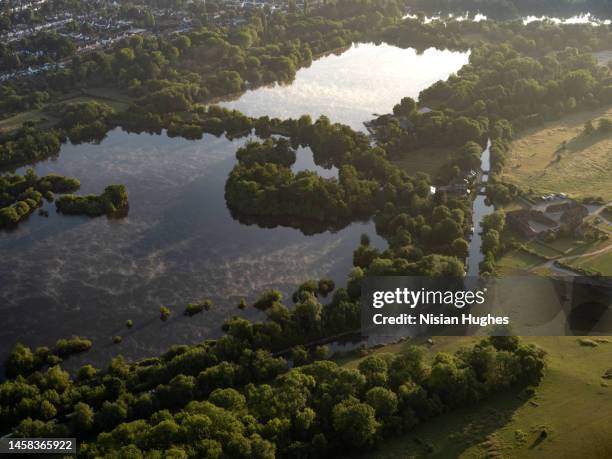 aerial view flying high up over a savay lake in england, view looking east at the rising sun. - lamaçal imagens e fotografias de stock