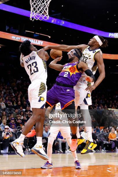 Josh Okogie of the Phoenix Suns attempts a shot over Aaron Nesmith of the Indiana Pacers and Myles Turner during the second half at Footprint Center...